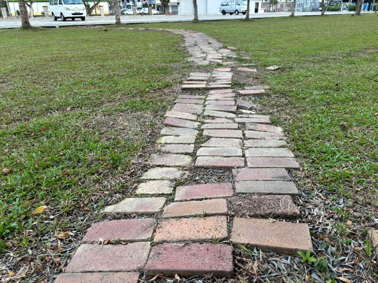 穿過校園草地並朝向校外延伸的磚路